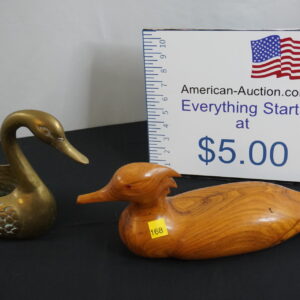 wooden duck with red eyes and brass duck