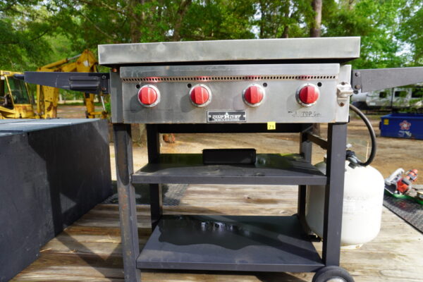 Camp Chef Flat top gas grill 4 burners on wheels, has a homemade stainless still cover